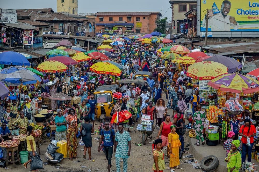 Shoppers and traders moving between busy stalls at Balogun Market on Lagos Island.
