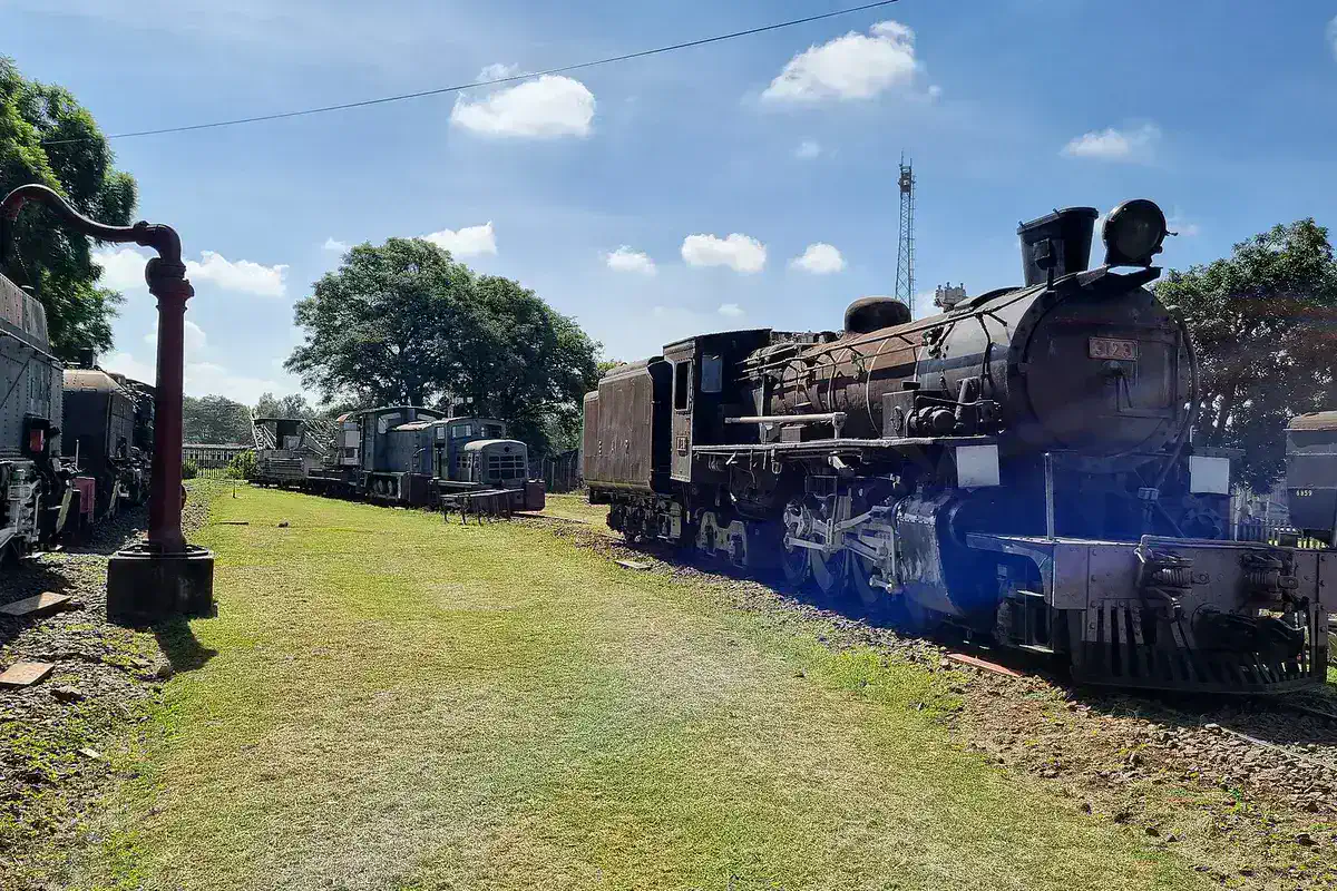 Historic steam locomotives displayed outdoors at Nairobi Railway Museum.