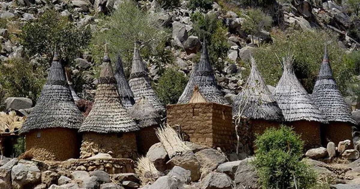 Traditional stone houses with conical thatched roofs on the rocky slopes of Sukur Cultural Landscape.