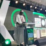 Oba Akintoye Adeoye speaking at the Amadeo Business Summit in Enugu, or a residential estate under construction in Enugu.