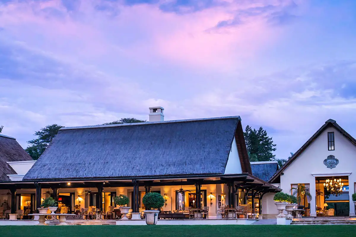 Main lodge exterior and garden at Royal Livingstone Hotel by Anantara at dusk