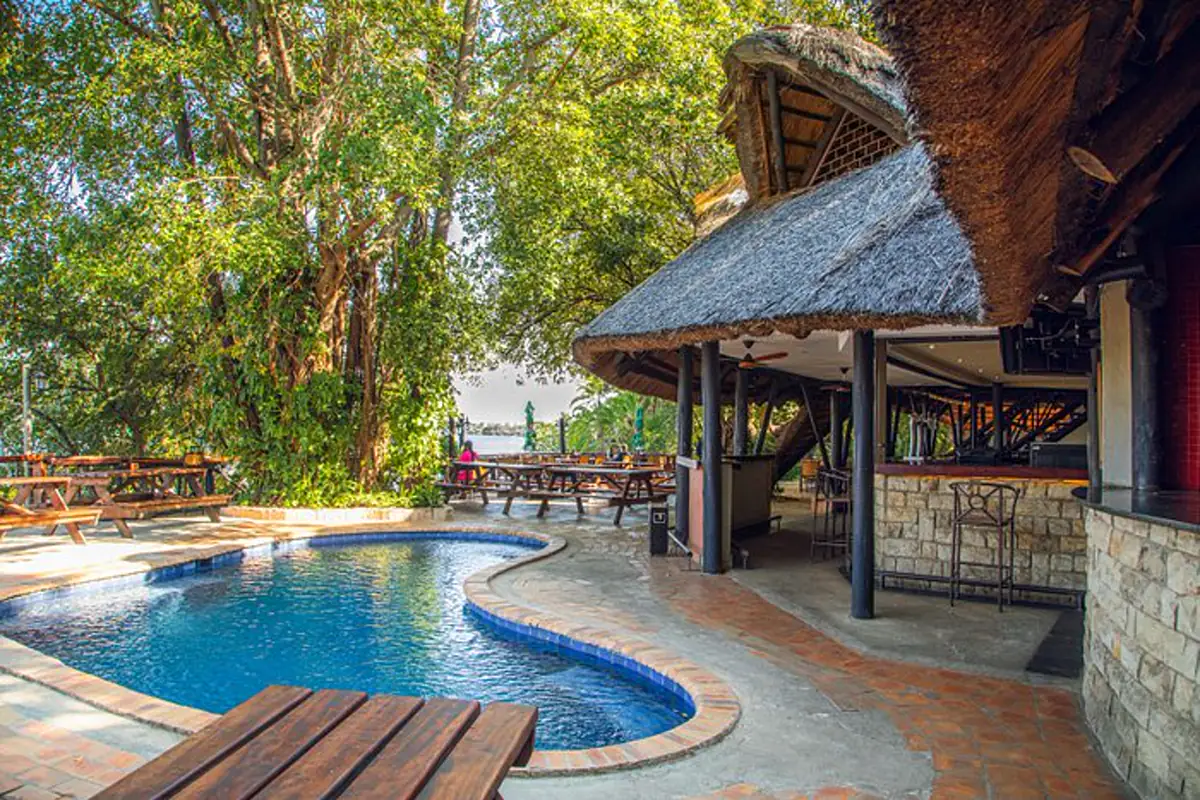 Swimming pool and thatched riverside deck at The Victoria Falls Waterfront Lodge in Livingstone